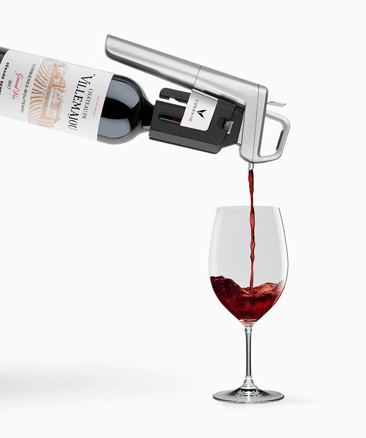 Red wine being poured from a bottle into a wine glass, featuring the label "Château de Villemajou."