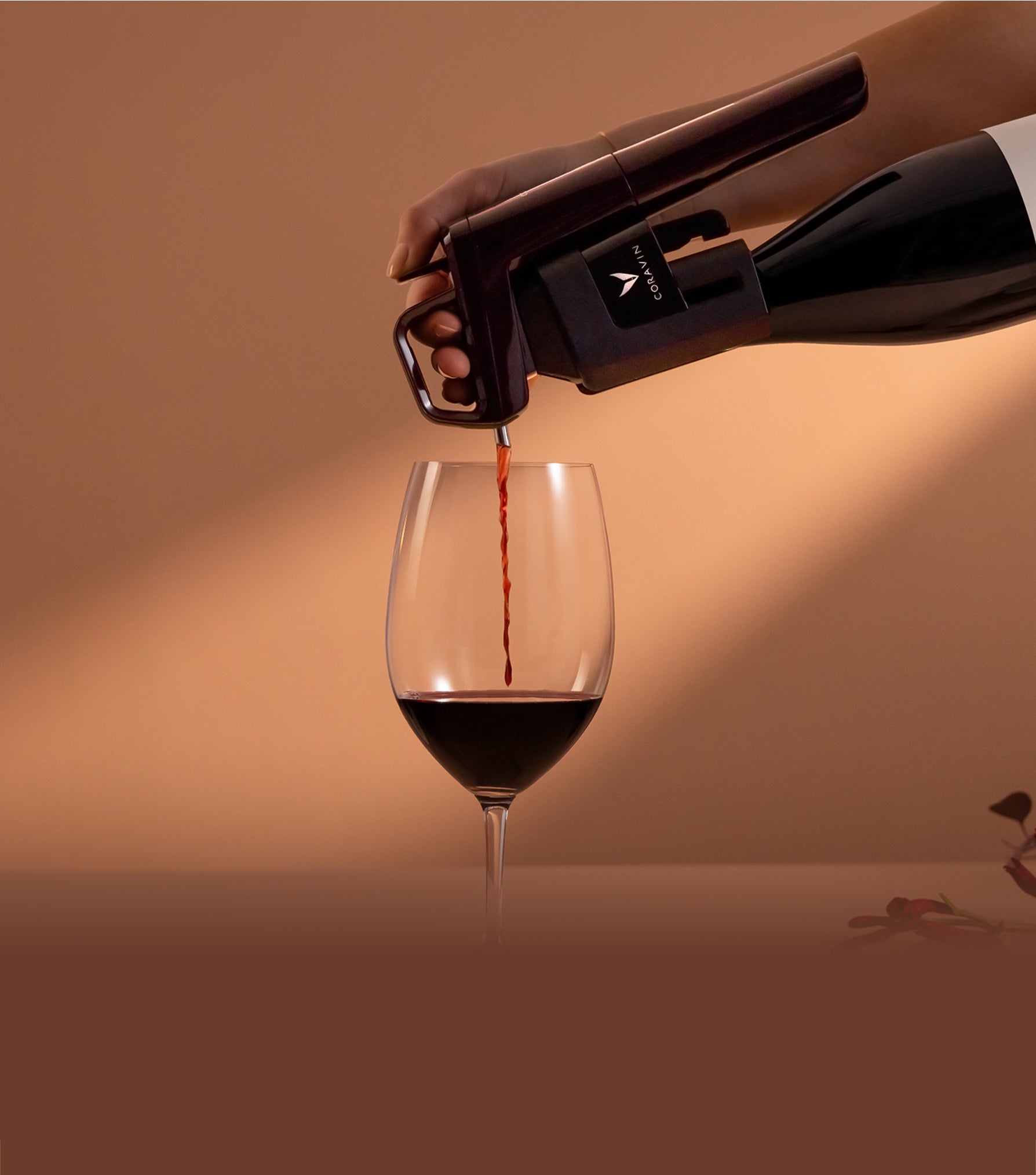 Wine bottle being opened with a Coravin against a warm brown background